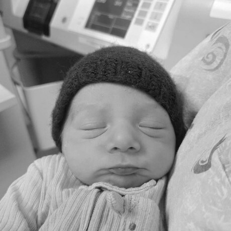 Baby Leo asleep in his maroon beanie